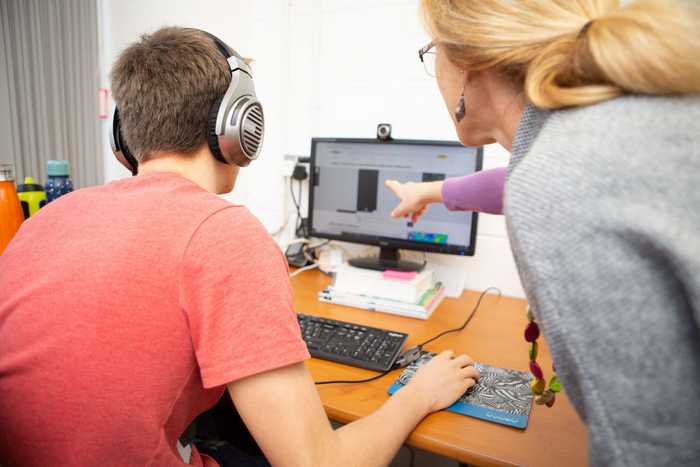 Lady teaching a student using a computer