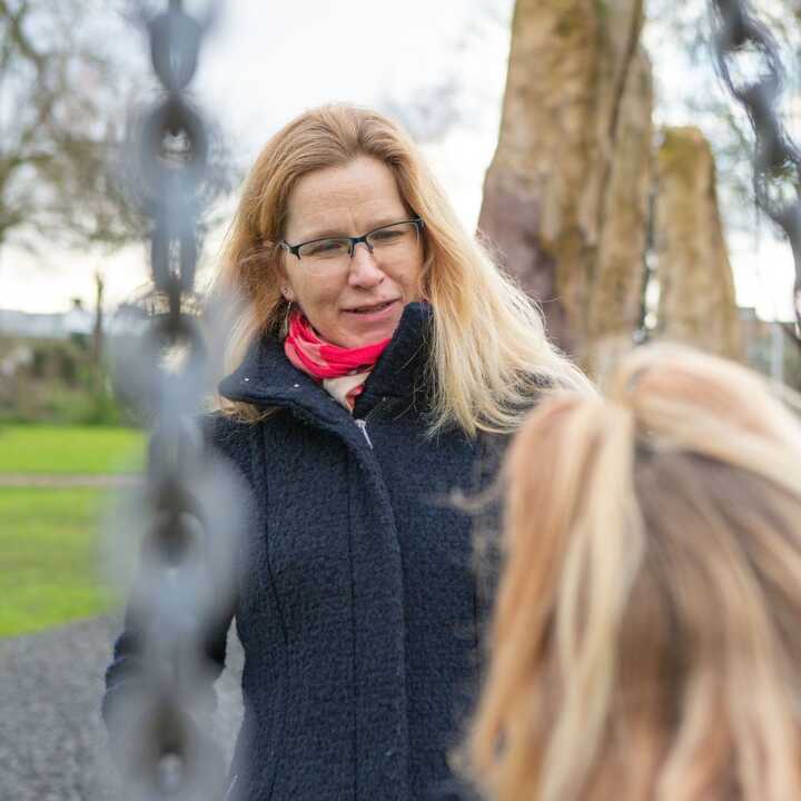 A case manager talks to a child at a playground.